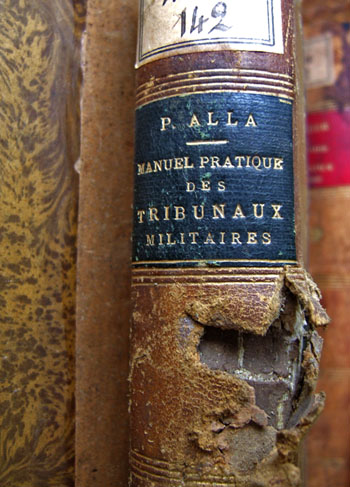 Dos d'un livre de la Bibliothèque de l'École militaire de Paris portant la trace d'un projectile, souvenir du 25 août 1944